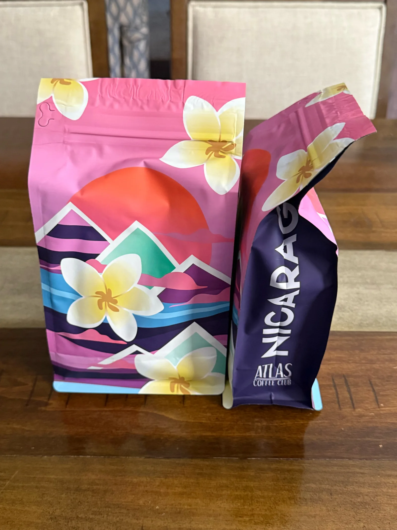 Two Atlas bags, one from the front with flower and mountain artwork and one from the side reading "Nicaragua"