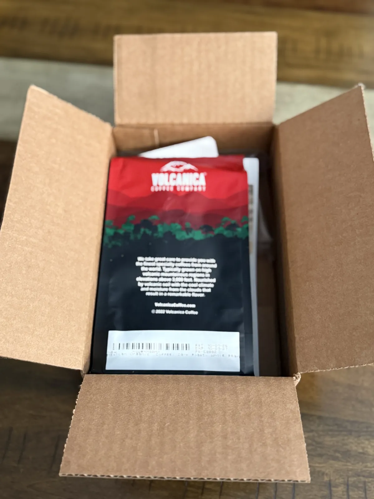 Opened shipping box with the red and black Volcanica bag inside